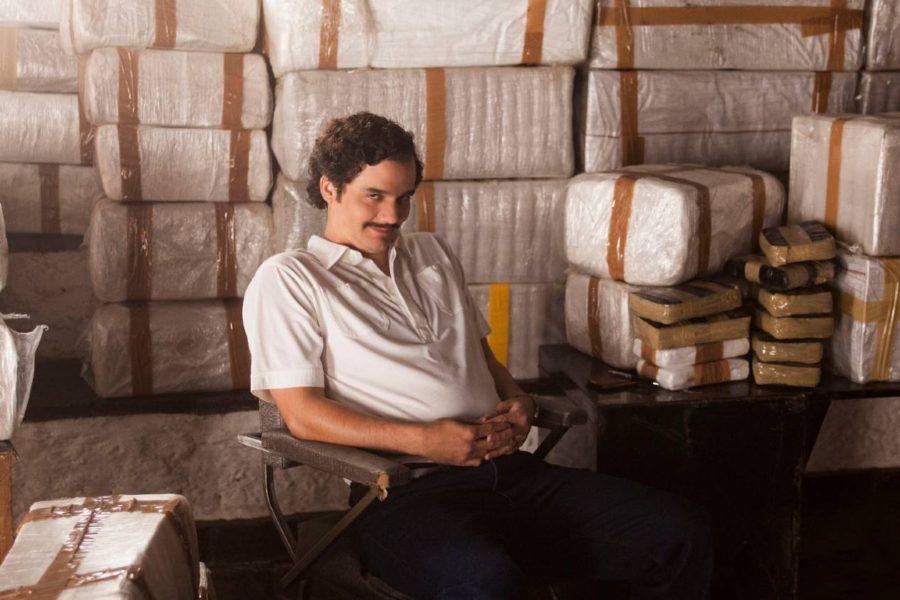 Pablo Escobar, protagonista de la serie Narcos, sentado junto a grandes cantidades de cocaína